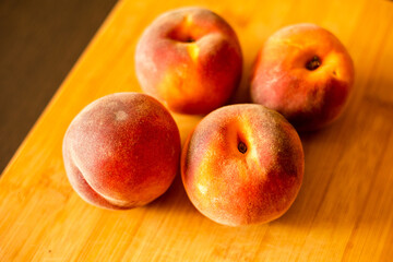 Wall Mural - Ripe peaches on wooden board close up