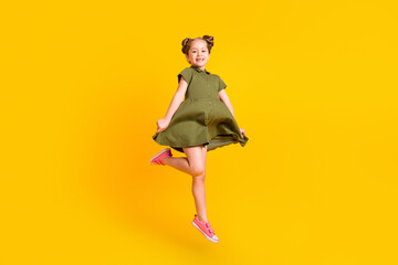 Wall Mural - Full size portrait of active energetic person jumping have fun hold dress isolated on yellow color background