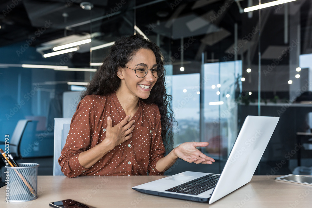 Happy hispanic businesswoman working in modern office using laptop for ...