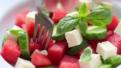 Wall Mural - Watermelon salad with feta cheese, cucumber and basil in plate, close-up. Summer recipe, healthy diet, detox food.