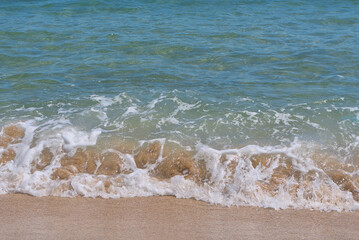 Clear emerald green sea with white foam