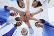 © Peakstock - Bottom view of multiethnic medical team putting hands together in circle for success work. Patients health in doctors hands