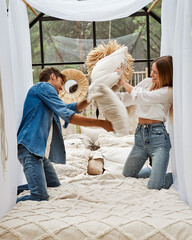 Wall Mural - Young couple having fun with pillow fight