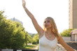 © brillianata - Happy blonde woman on the city street with old buildings and trees. Summer sunny day