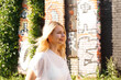 © brillianata - Young beautiful blonde on the street of urban art space. The concept of creating an art space and festivals in abandoned buildings. Old building.