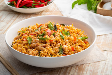 Wall Mural - Spicy stir fried instant noodle with minced pork and holy basil leaves in white plate