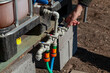 © glebchik - Hand opens tap on plastic irrigation system