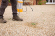Spraying weeds in garden. Man using weed killer spray, UK