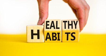 Healthy habits symbol. Concept words Healthy habits on wooden cubes. Doctor hand. Beautiful yellow table white background. Medical and healthy habits concept. Copy space.