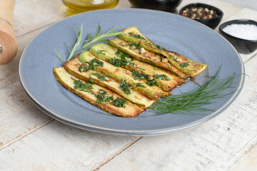 Wall Mural - Fried zucchini on plate over wooden background with free text space. Top view