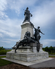 Ottawa, Ontario, Canada: Parliament Hill Monument Honoring Queen Victoria Standing On A Granite Pedestal Wearing Royal Attire, Gazing At The City. Young Woman Represents Canada. Lion Guards City