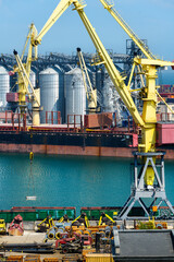 Wall Mural - industrial seaport infrastructure, sea, cranes and dry cargo ship, grain silo, bulk carrier vessel and grain storage elevators, concept of sea cargo transportation