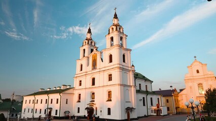 Wall Mural - Minsk, Belarus. People Walking Near Cathedral Of The Holy Spirit During Summer Evening. Minsk City In A Historic Area Nemiga. Time Lapse Timelapse.