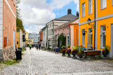Colorful and picturesque shops, cafes and wooden buildings line the main cobblestone road through the medieval Old Town of Porvoo, Finland.