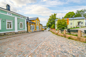 Wall Mural - Colorful wooden buildings line the cobblestone road at the entrance to the medieval old town of Porvoo, Finland.