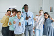 © Seventyfour - Portrait of smiling teacher posing with diverse group of children and showing hand signs