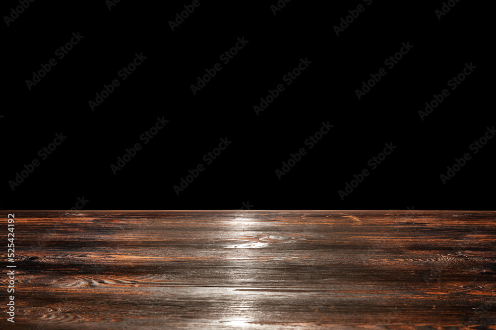 Wooden table top on black background