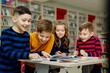 © Tina kids photo - school children in the library reading books, doing homework, prepare a school project for lessons
