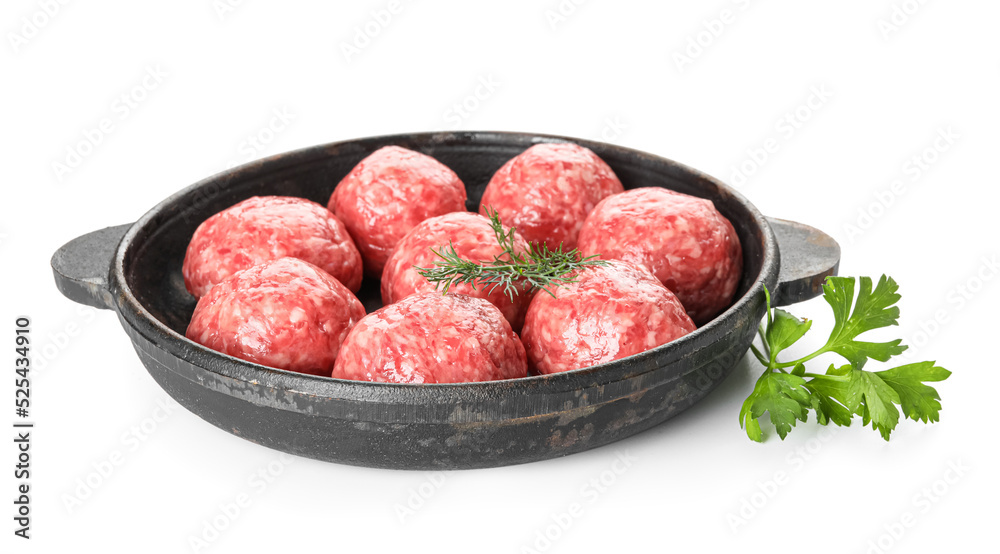 Baking dish with raw meat balls, parsley and dill on white background