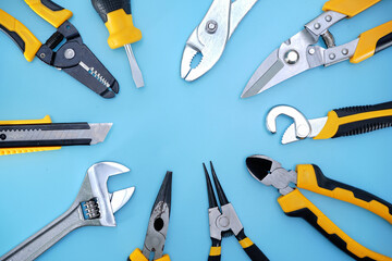 Wall Mural - different type of yellow and black hand tools flat lay isolated baby blue background with copy space 