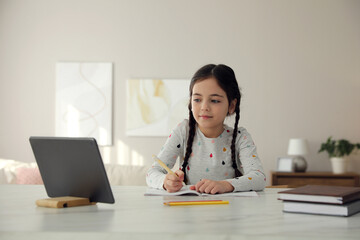 Sticker - Little girl doing homework with modern tablet at home