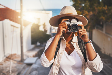 Photographer, travel or tourist taking pictures or photos outdoors in a new town. Traveler using a camera while on a trip at a vacation or holiday location on a sunny day doing a photoshoot