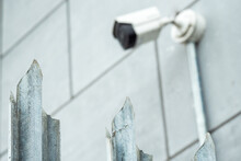 Sharp Spikes On A Metal Fence In Focus. CCTV Digital Camera Out Of Focus. Safety And Security Concept. Layered Defense.