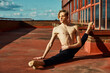 © ADDICTIVE STOCK - Young slender performer doing splits on roof