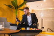 © ADDICTIVE STOCK - Positive businessman using smartphone at table with food