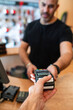 © ADDICTIVE STOCK - Cashier giving payment terminal to client