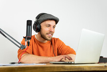 Focused Man Browsing On Laptop And Reading Documents While Recording Studio