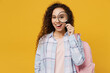 © ViDi Studio - Young surprised excited happy fun black teen girl student she wear casual clothes backpack bag hold magnifying glass isolated on plain yellow color background. High school university college concept.
