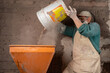 © ADDICTIVE STOCK - Man poring dry mix into plaster station