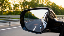 Look In The Rear View Mirror Of A Car. Car Driving On The Road.