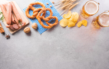 Wall Mural - Oktoberfest festival decoration symbols made from Pretzel loaf, beer, sausage, potato chips and Bavarian white and blue fabric on stone background.