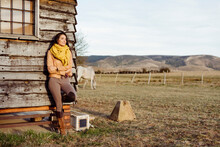 Stylish Woman On Ranch Standing In A Wooden Cabin