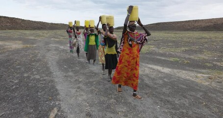 climate change,drought,water crisis.close-up front view.african woman walking home after collecting 