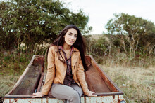 Charming Woman Sitting On Rusty Wagon In Countryside