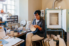 Skilled Artisan Woman Painting Pottery In Workshop