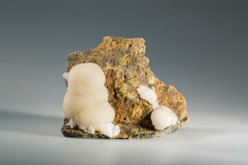 A sample of a natural mineral Aragonite (carbonate class) white spherolites on serpentinite calcium carbonate polymorph. Museum Mineral Series. Mineralogical sample