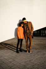Modern Black Man And Woman Against White Wall In Sunset