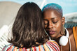 © ADDICTIVE STOCK - Multi ethnic lesbian couple hugging outdoors