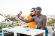 © ADDICTIVE STOCK - Lesbian couple taking selfie on balcony
