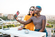 © ADDICTIVE STOCK - Lesbian couple taking selfie on balcony