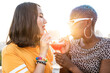 © ADDICTIVE STOCK - Multiethnic couple of cool lesbian women drinking cocktails