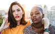 © ADDICTIVE STOCK - Stylish couple of multiracial lesbian women embracing in street