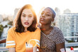 © ADDICTIVE STOCK - Multiethnic couple of cool lesbian women drinking cocktails