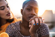 © ADDICTIVE STOCK - Multi ethnic lesbian couple relaxing with cocktails
