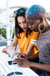 © ADDICTIVE STOCK - Multiethnic couple of cool lesbian women drinking cocktails
