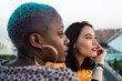 © ADDICTIVE STOCK - Multiracial lesbian couple sitting close together outdoors